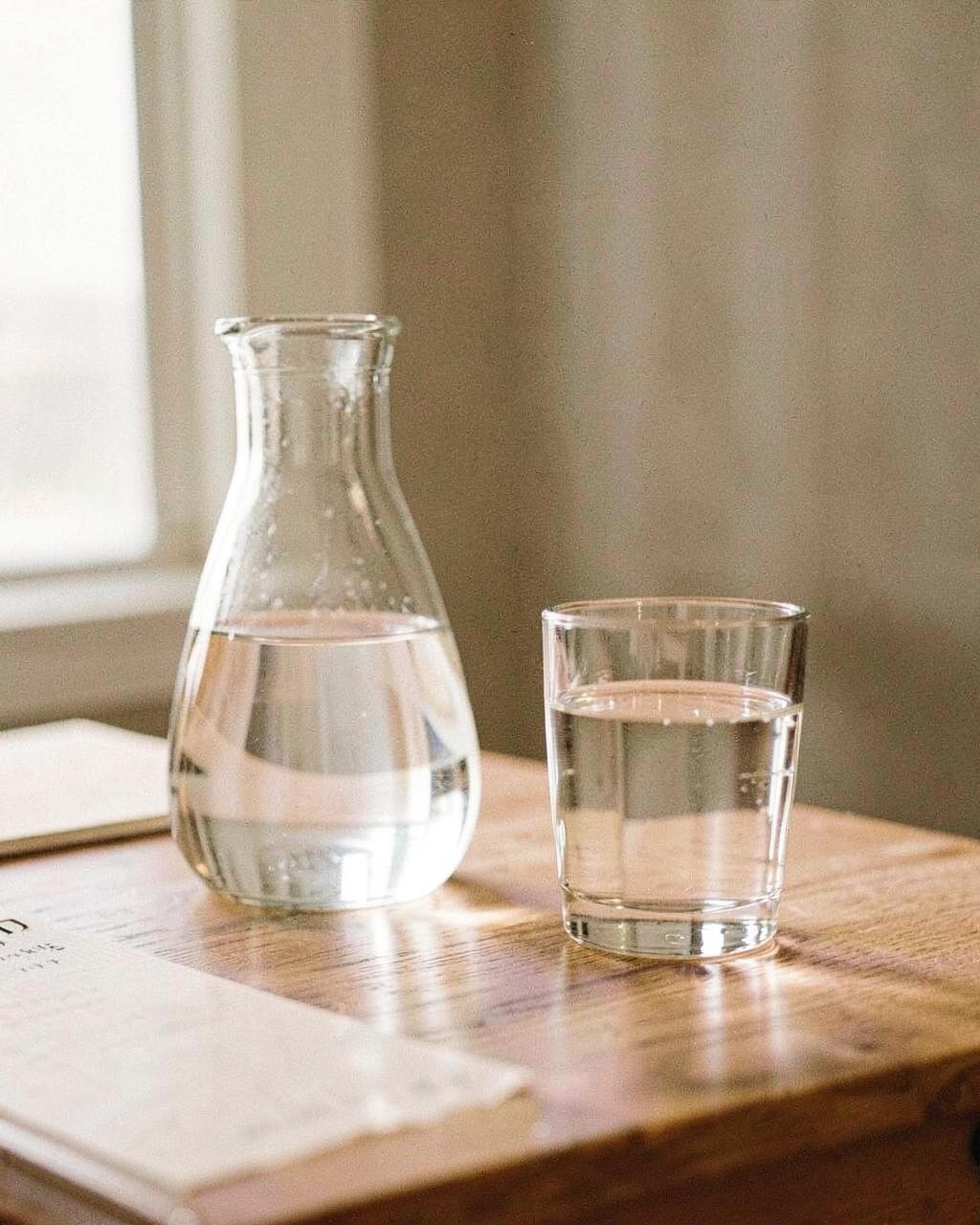 Glas Wasser auf einem hellen Tisch im Tageslicht